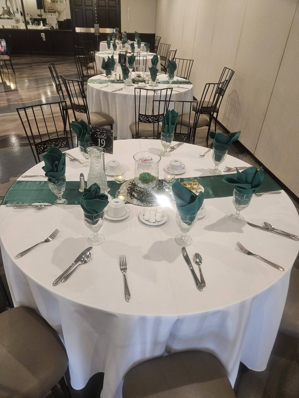 A Maravela's place setting with green roses on a banquet table