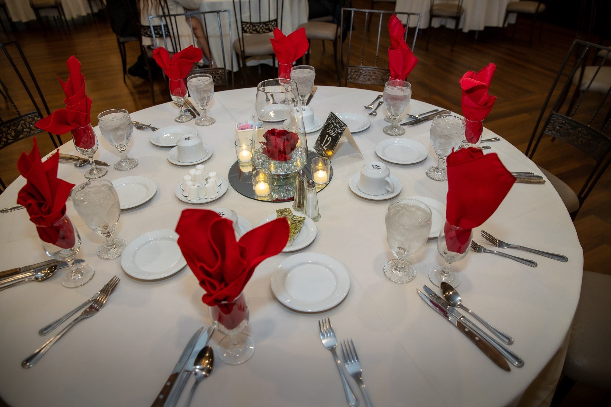 A Maravela's table set with red roses, candles, and place settings