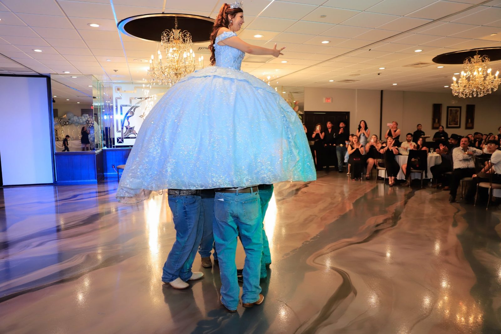 A quinceañera twirls in her ball gown on the new marbled floor at Maravela's