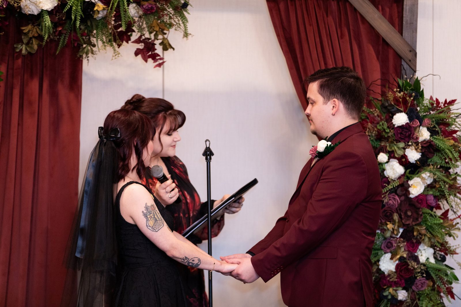 A couple exchanges vows beneath the ceremony arch at Maravela's