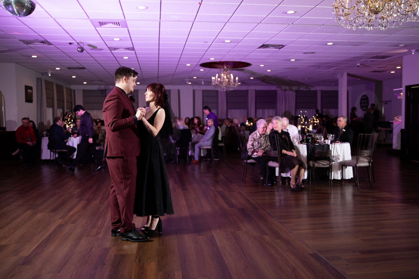 A couple's first dance on the Maravela's ballroom floor under violet uplighting